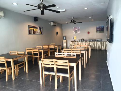 a dining room with tables and chairs and a ceiling fan at Golden Court Hotel - Tun Abdul Razak in Johor Bahru