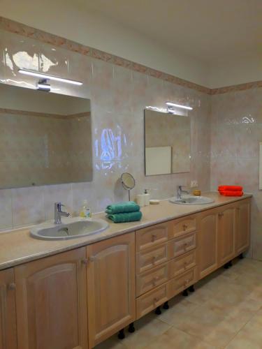 a bathroom with two sinks and a large mirror at Casa de Sabine in Olhão