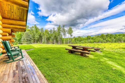 a picnic table and a green chair on a lawn at Eaglet Log Home in Franconia