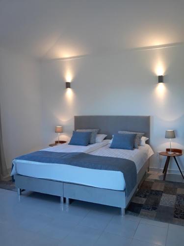a bedroom with a large bed with blue pillows at Casa de Sabine in Olhão