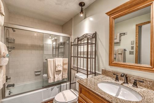 a bathroom with a sink and a shower and a mirror at Bee Branch 24 in Sugar Mountain