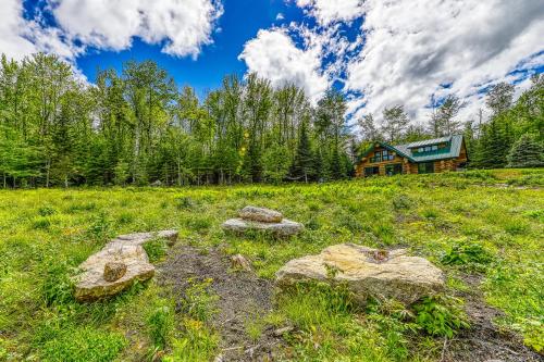 a house on a hill with rocks in a field at Eaglet Log Home in Franconia