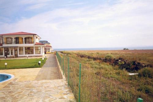 a house on the beach with the ocean in the background at Apartment Rutland Beach in Ravda