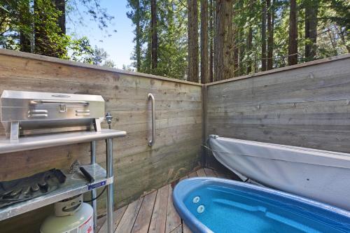 a bathroom with a tub and a wooden wall at Cabin 55 in Sea Ranch