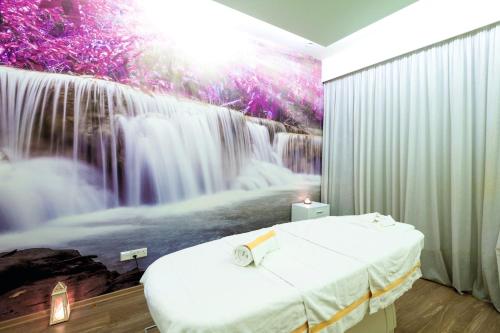 a bedroom with a waterfall mural on the wall at Tofinis Hotel in Ayia Napa