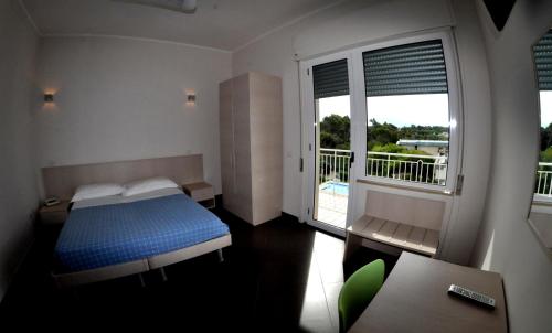 a bedroom with a blue bed and a balcony at Albergo Riviera Spineta in Battipaglia