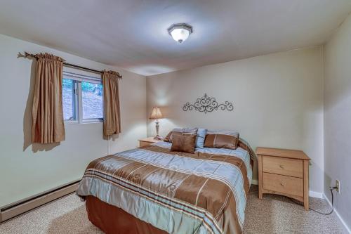 1 dormitorio con 1 cama, mesita de noche y ventana en Briarcliff, en Sugar Mountain