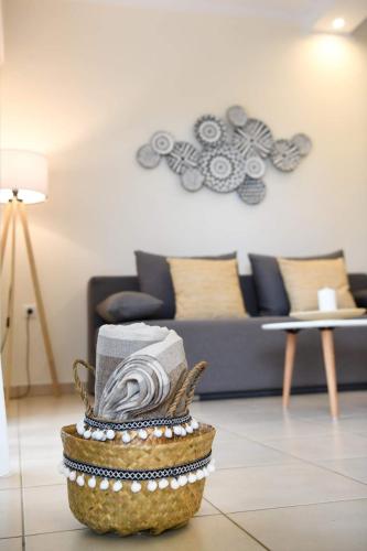 a living room with a couch and a basket with towels at Anemi Deluxe Apartment in Kolios