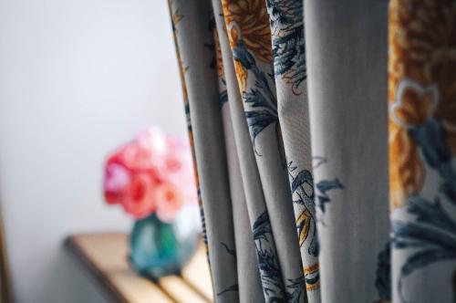 a curtain with a vase of flowers on a shelf at Palais Bad Ragaz in Bad Ragaz