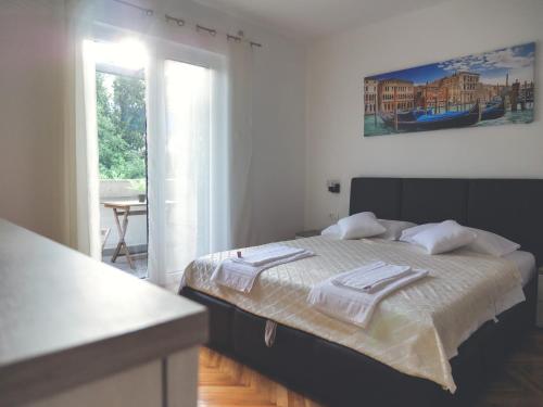 - une chambre avec un lit et des serviettes dans l'établissement Apartment LIM, à Budva