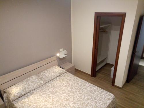 una piccola camera con letto e specchio di b＆b casa d'amicis a Roccaforzata