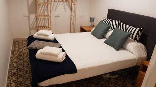 a bedroom with a large bed with towels on it at CARROS 19 in Vilanova i la Geltrú