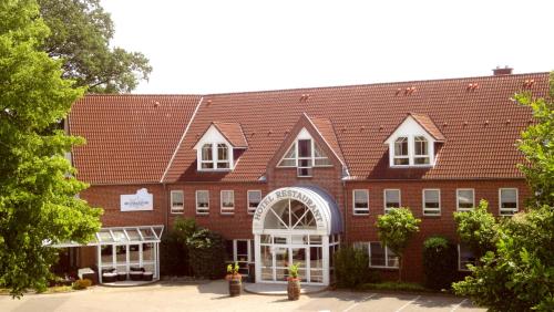 a large brick building with a red roof at Wildeshauser Hof in Wildeshausen