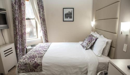 a bedroom with a bed and a window at Da Vinci Hotel in New York