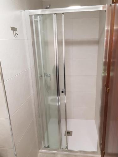 y baño con ducha y puerta de cristal. en Fantástico apartamento cerca de la playa en Benicàssim