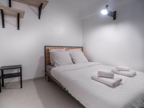 une chambre avec un lit avec des draps blancs et des serviettes dans l'établissement Appartement centre de Cannes, à Cannes