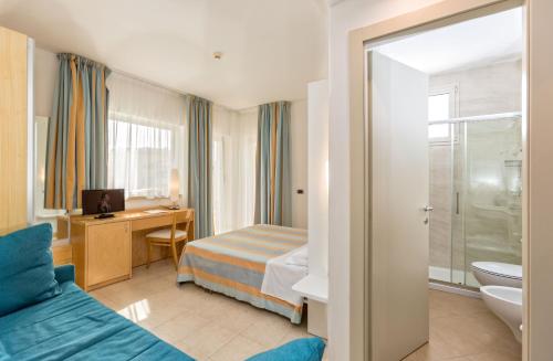 um quarto de hotel com uma cama e uma casa de banho em Almaluna Hotel & Resort em Alba Adriatica