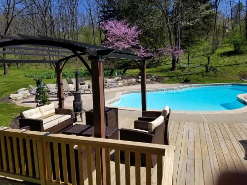 Hawk Mountain Bed & Breakfast في Kempton: مسبح مع شرفة بجانب شرفة خشبية