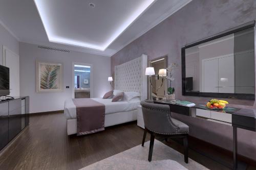 a bedroom with a bed and a desk with a television at Hotel President Terme in Abano Terme