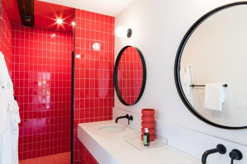 a red tile bathroom with a sink and a mirror at The Russell in Nashville