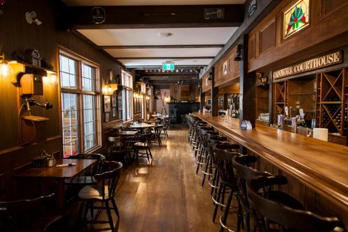 a bar with tables and chairs in a restaurant at The Georgetown Inn in Canmore