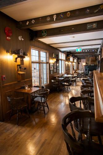 a restaurant with tables and chairs and a bar at The Georgetown Inn in Canmore