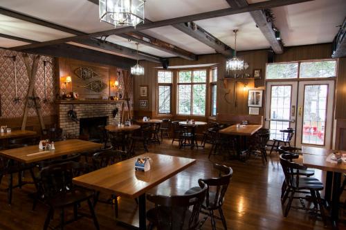 um restaurante com mesas e cadeiras de madeira e uma lareira em The Georgetown Inn em Canmore