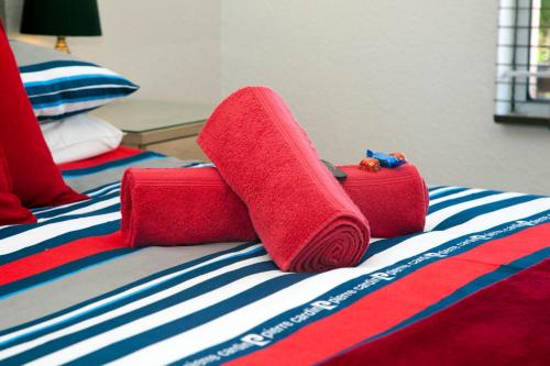 two red towels sitting on top of a bed at 5 Key Largo in Amanzimtoti