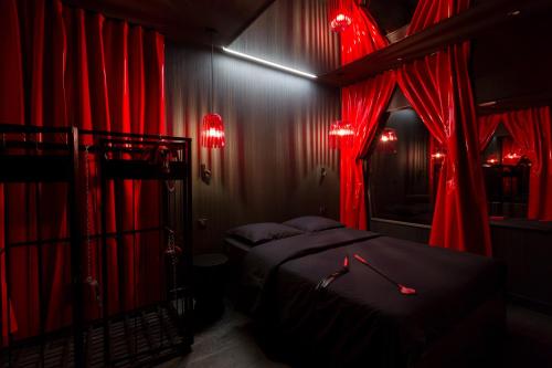 a hotel room with a red curtain and lights at L'hôtel in Paris