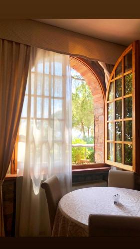 a table with a white curtain and a window at Hotel Villa San Giorgio in Poggibonsi