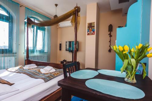 sypialnia z łóżkiem i stołem z wazonem kwiatów w obiekcie Pensjonat Kolory Świata w Solcu-Zdroju