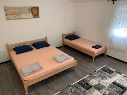 two beds in a small room with at Apartman Grande Ajna in Mostar
