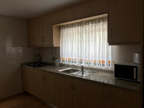a kitchen with a sink and a window at Casa Dos Cabecinhos in Paradamonte