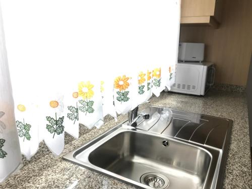 a kitchen counter with a sink and a window at Casa Dos Cabecinhos in Paradamonte