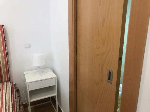 a bedroom with a door and a table with a lamp at Casa Dos Cabecinhos in Paradamonte