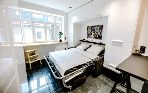 ein weißes Schlafzimmer mit einem Bett und einem Schreibtisch in der Unterkunft Studio les Parmentiers in Metz