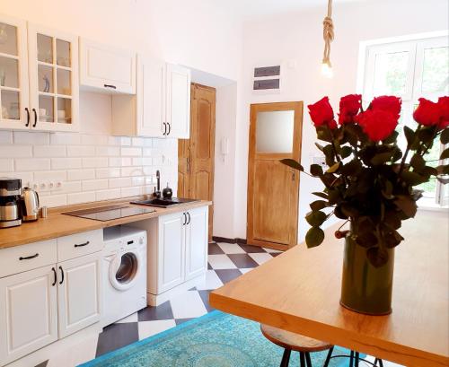 a kitchen with a table with a vase of roses at Topolove Rooms & Apartments in Krakow