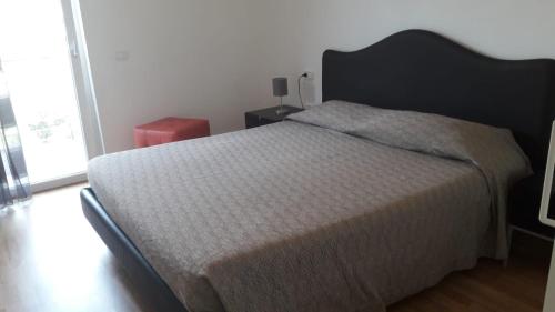 1 dormitorio con 1 cama grande y cabecero negro en Ca' Dell' Ora, en Nago-Torbole