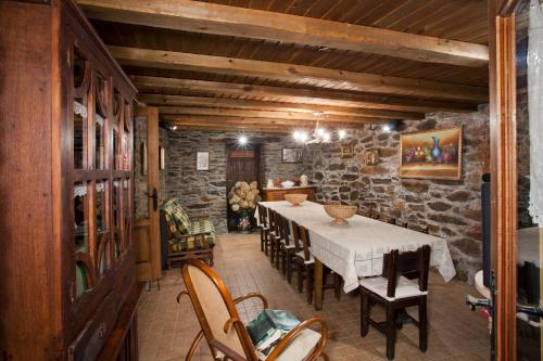 comedor con mesa, sillas y pared de piedra en Casa Ponce en Posada de Rengos