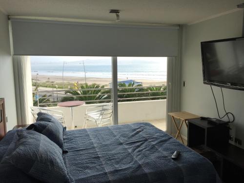 1 dormitorio con cama y vistas al océano en Departamento Marserena frente al mar, en La Serena