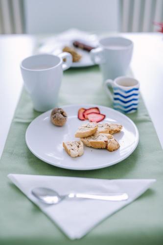 a white plate with cookies on it on a table at Pangea e Panthálassa B&B in Lecce