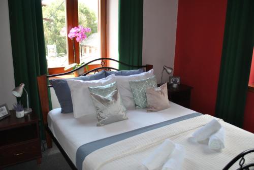 a bedroom with a white bed with pillows and a window at Vienna Story Guesthouse in Mostar