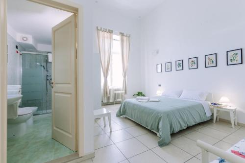 a white bedroom with a bed and a bathroom at Pangea e Panthálassa B&B in Lecce