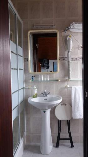 a bathroom with a sink and a mirror and a stool at Country House Alfarim in Alfarim