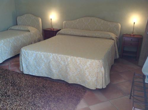 a bedroom with two beds and two night stands at Locanda San Lorenzo in Roddino