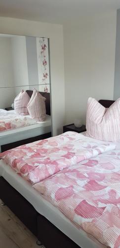 een slaapkamer met 2 bedden met roze en witte lakens bij Ferienwohnung Kriemhild in Xanten