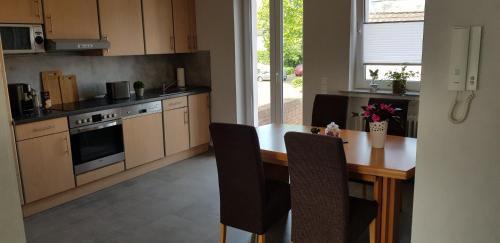 a kitchen with a wooden table with chairs and a stove at Ferienwohnung Kriemhild in Xanten