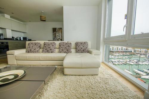 a living room with a couch and a table at Orion Marina Sea View - Parking - by Brighton Holiday Lets in Brighton & Hove