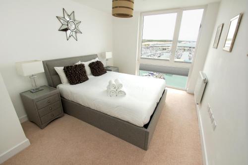 a bedroom with a bed and a large window at Orion Marina Sea View - Parking - by Brighton Holiday Lets in Brighton & Hove
