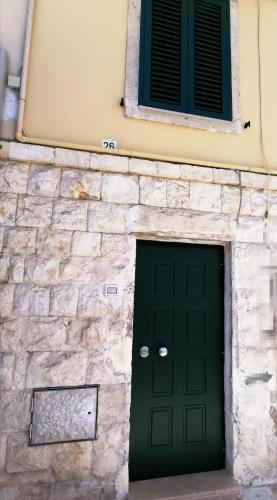 un edificio con una porta verde e una finestra di Ventisei a Molfetta